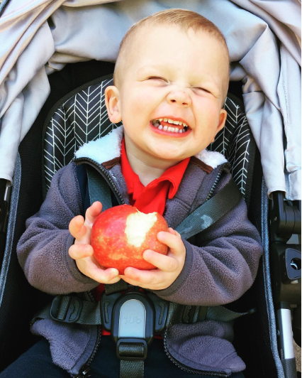 Photo of boy eating an apple.
