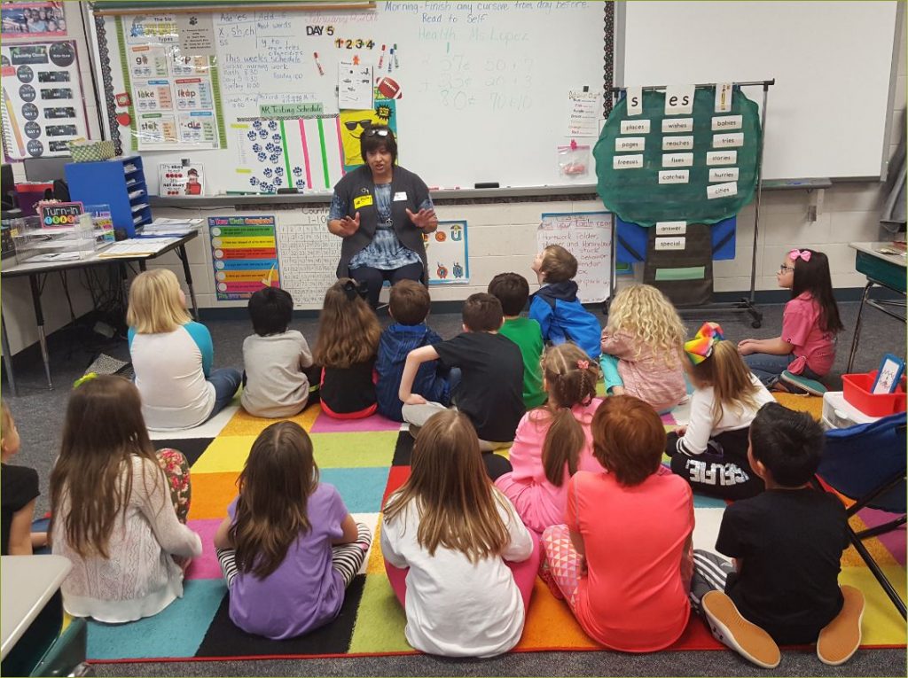 Photo of a teacher reading to children.